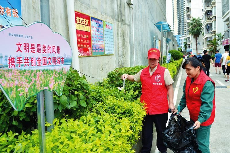 志愿者在住宅小区清理绿化带里的垃圾
