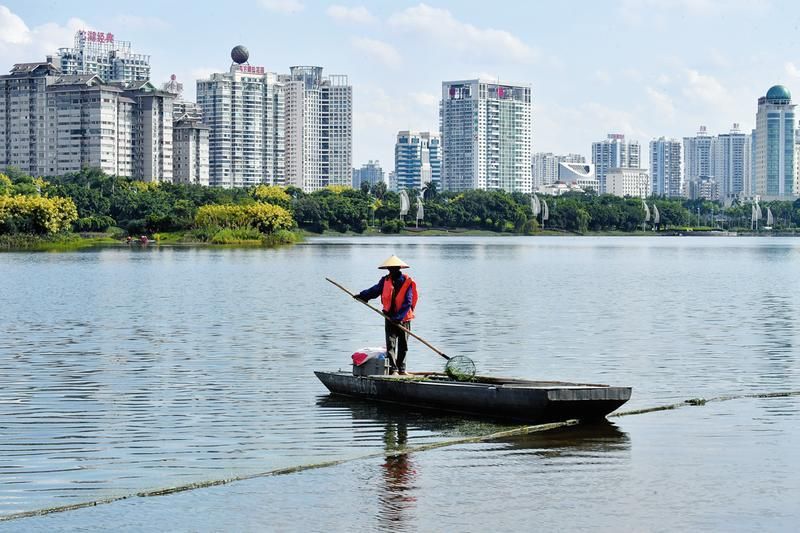 环卫工人在清理南湖里的水草杂物，保持环境清洁优美
